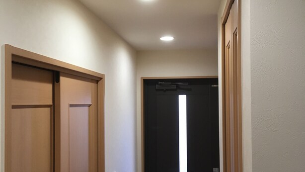 A hallway with wooden doors and a black door with a vertical light strip. - Near JR AWAJI station <br> 30 min. to Kyoto .10 min. to umeda.<br> 40 min.<br> (Osaka city higashiyodogawa ku)