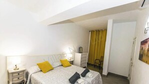 A bedroom with a bed, bedside tables, a dresser, and a chair. - Vista Maritima 1B - Seafront Stay by Villas Now (Playa Blanca)