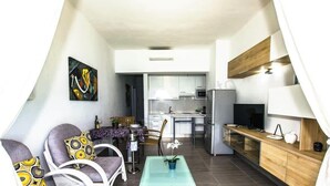 A modern apartment with a dining area, kitchen, and a living space with a sofa and a coffee table. - Vista Maritima 1B - Seafront Stay by Villas Now (Playa Blanca)