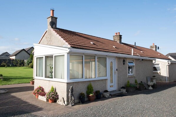 Stunning single-story house with a conservatory offering a garden view.
