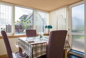 Enjoy meals for two in this cozy dining area with a table set and comfortable seating.