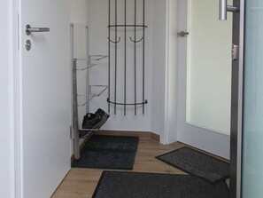 A hallway with a shoe rack, a door, and a doormat. - Leuchtturmstraße house 17, only 100 m from the Baltic Sea - Leuchtturmstraße (Rerik)