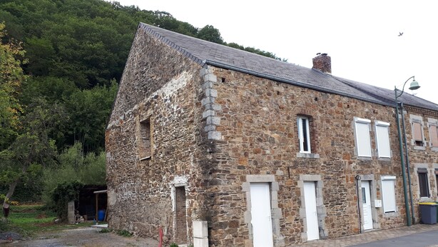 A stone building with a sloped roof, multiple windows, and a door. - Country house in country stone (Landrichamps)