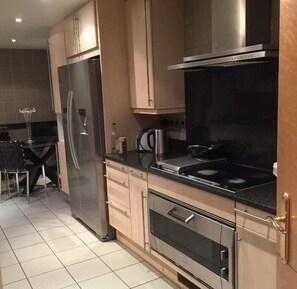 Enjoy cooking in this well-equipped kitchen with a refrigerator, oven, and stove.