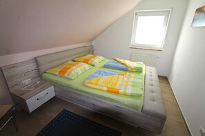 A bedroom with a bed, a desk, and a window. - Leuchtturmstraße house 15, only 150 m from the beach - Leuchtturmstraße 31 (Rerik)
