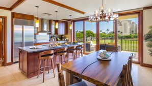 Una cocina moderna con una isla grande, taburetes de bar y una mesa de comedor.