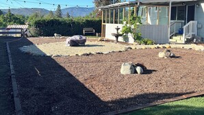 A residential property with a covered patio, a satellite dish, and a gravel driveway.
