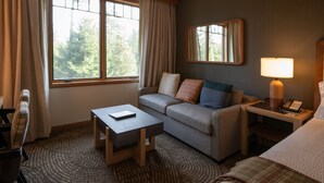 Une chambre d’hôtel avec un canapé, une petite table, une lampe et un lit.