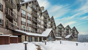 Un hôtel à plusieurs étages, doté de balcons et dont le sol est recouvert de neige.