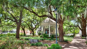 A gazebo surrounded by mature trees with moss, a brick pathway, and a bench. - Heated Pool Access | 5*Clean | Flex Cancelation (Savannah)