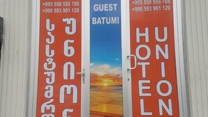 Entrada de un hotel con dos puertas, una con la leyenda 'GUEST BATUMI' y la otra 'HUNION HOTEL'.