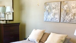 A bedroom with a bed, two pillows, a dresser, and a lamp. - Beautiful Updated Condo With Direct River View From Balcony!  We Love Dogs! (New Braunfels)