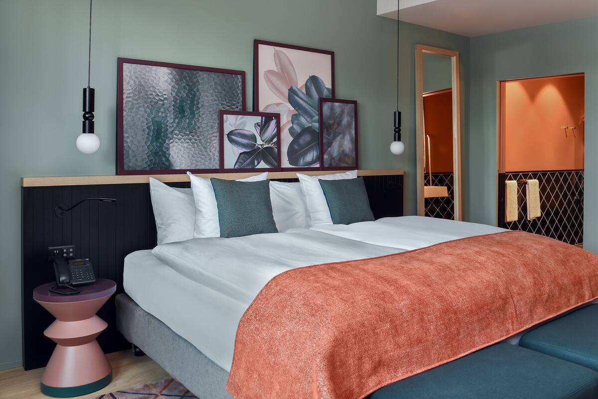 Ein modernes Schlafzimmer mit Bett, Nachttischen und Kunstwerken an der Wand.