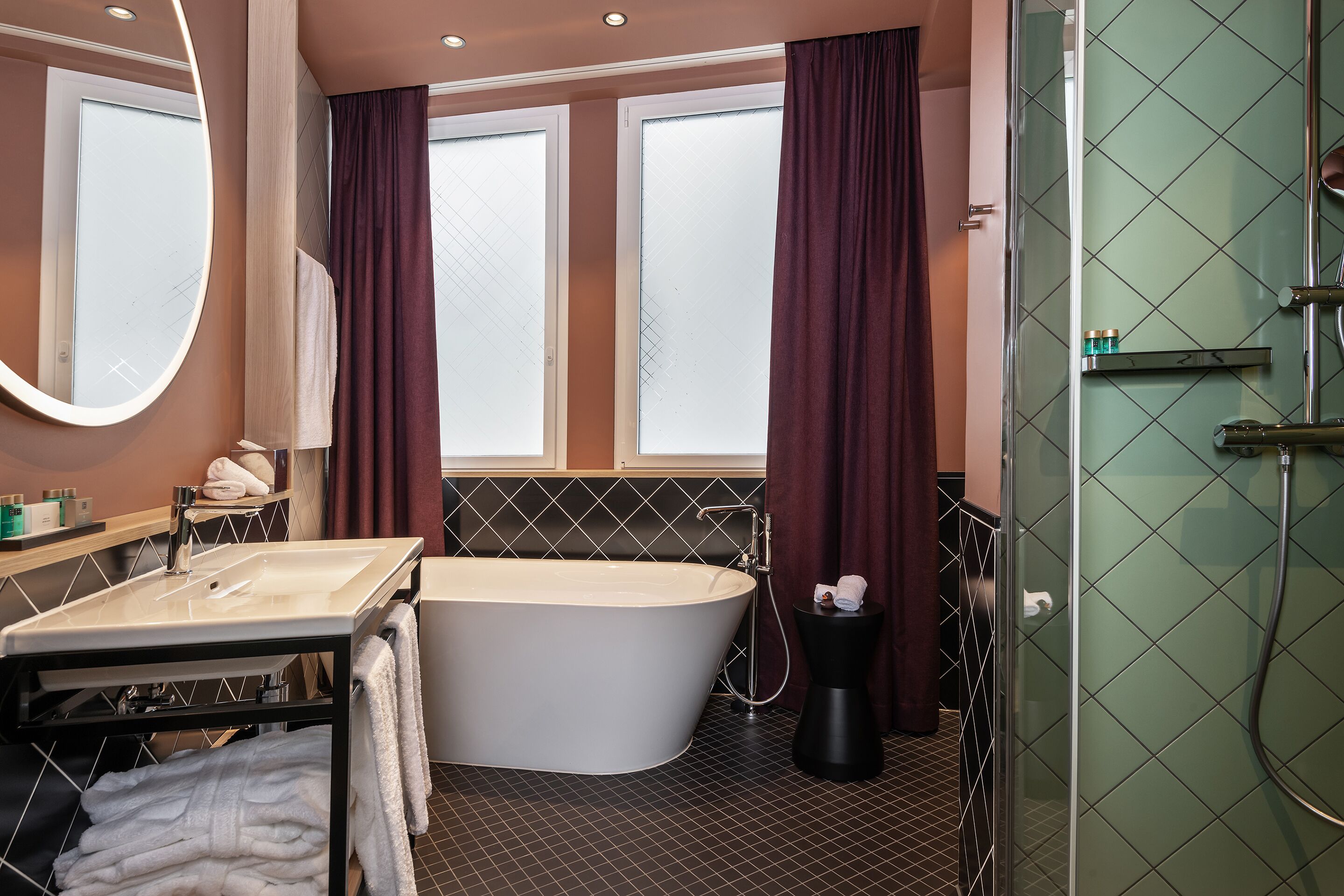 Un baño moderno con una bañera independiente, un espejo grande y cabina de ducha con paredes de vidrio.