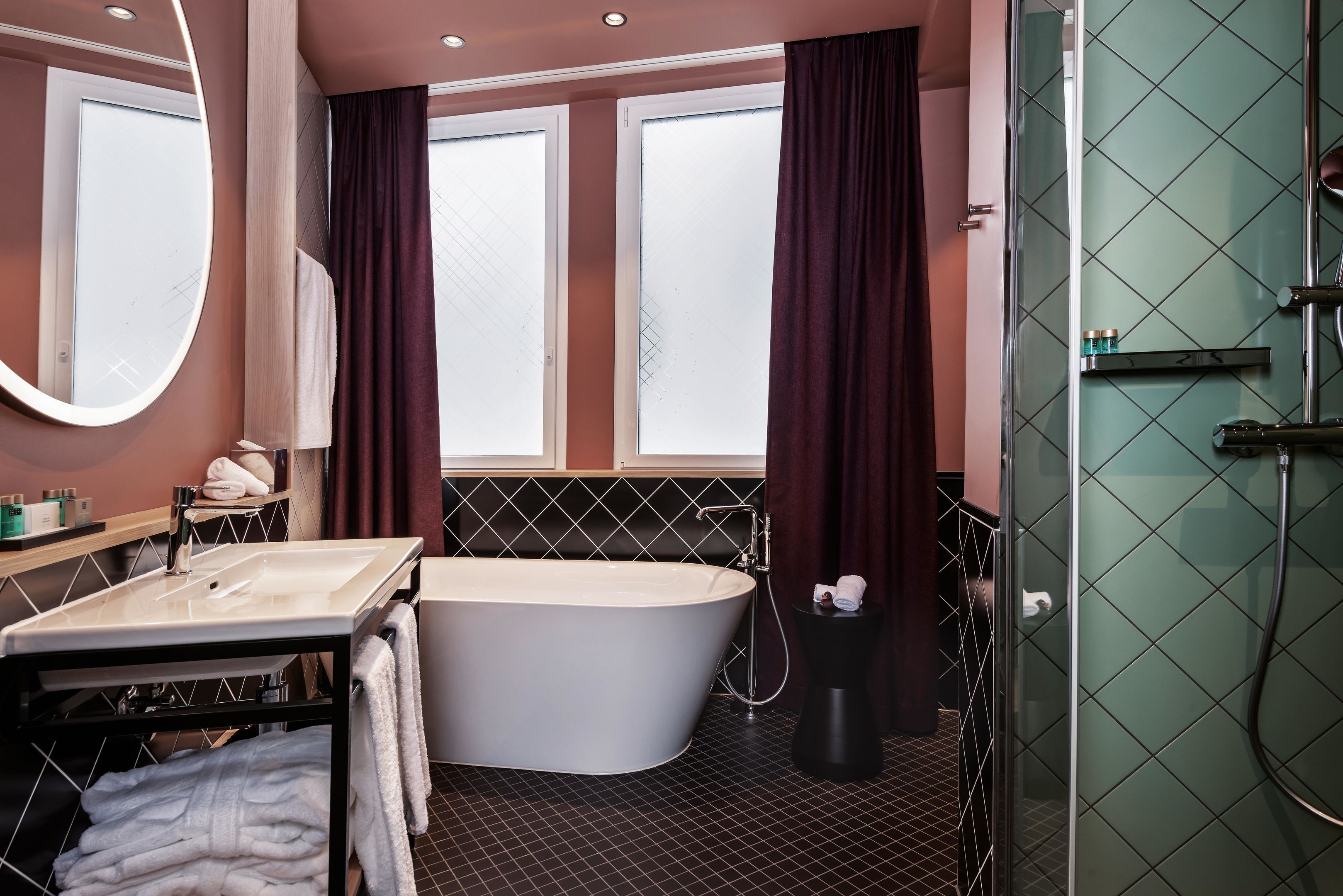 Ein modernes Badezimmer mit einer freistehenden Badewanne, einem großen Spiegel, einem Waschtisch und einer Duschkabine.