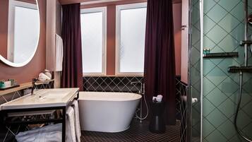 Ein modernes Badezimmer mit einer freistehenden Badewanne, einem großen Spiegel, einem Waschtisch und einer Duschkabine.