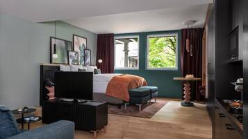 Un dormitorio moderno con cama, televisión y zona de estar.