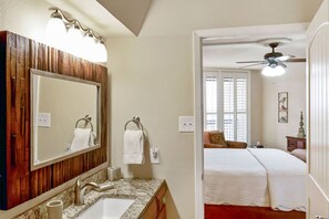 A bathroom with a wooden vanity, a sink, and a mirror. - Sandpiper Condominiums 603L, Panoramic Gulf Views w/ direct access to Mustang Island/Port A beaches. (Port Aransas)
