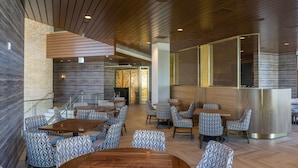 A modern interior with wooden panel ceilings, patterned seating, and a central bar area. - Legacy Resort Hotel & Spa (San Diego)