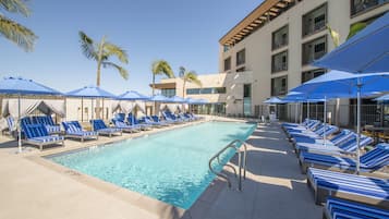 Una piscina al aire libre, camas de piscina gratis, sombrillas