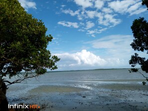 Praia particular, areia branca, espreguiçadeiras, guarda-sóis 