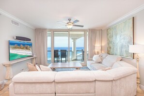 Relax in this stylish living area with a sofa facing a sliding glass door to a balcony overlooking the ocean.