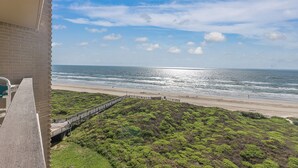 Ein Balkon mit Blick auf Strand und Meer.