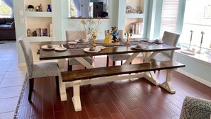 A dining room with a wooden table set for four, surrounded by patterned chairs. - 8BR lakefront Disney home w themed rms HarryPotter Frozen ToyStory Mario Royal (Kissimmee)