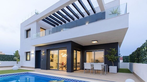 Une maison moderne à deux étages, dotée d’une piscine, de grandes fenêtres et d’un espace patio.