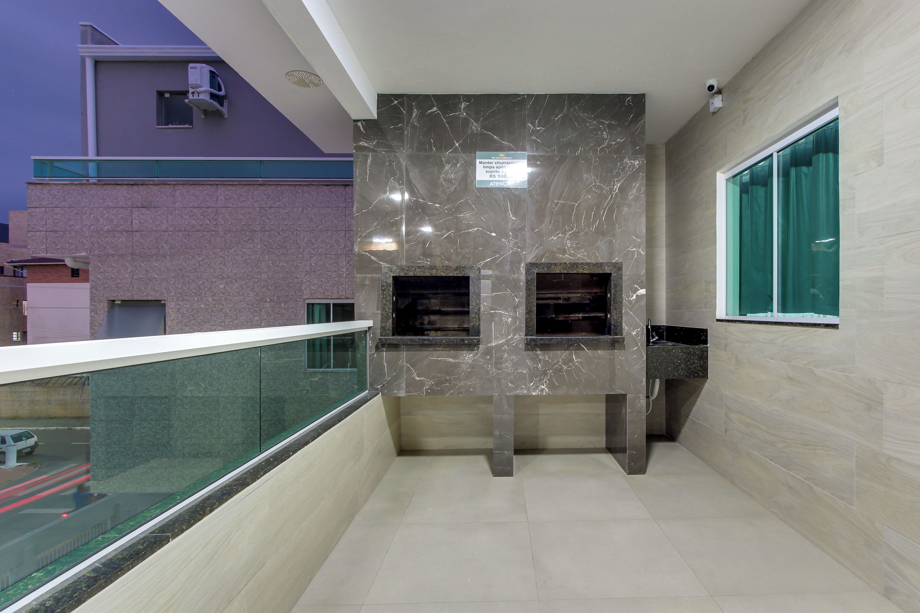 A modern building with a marble wall, a glass railing, and a sign indicating a price of Rs 100.