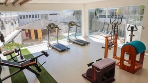 A gym with treadmills, a bench press, and a rowing machine. - Scaini Palace Hotel (Balneario Arroio do Silva)