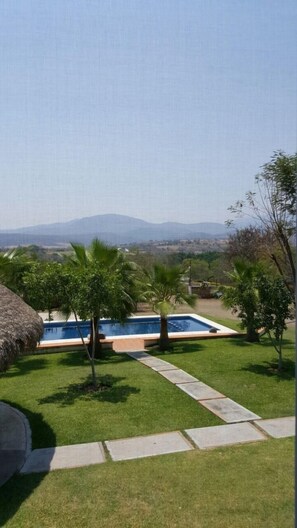 A pool area with a clear view of mountains in the background. - Casa Tehuixtla (Jojutla)