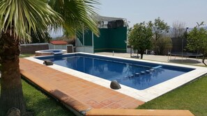 Alberca al aire libre y camastros 