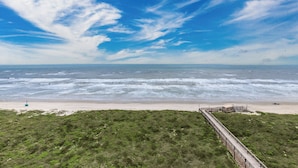 A beach with a wooden boardwalk leading to a sandy area. - Sandpiper Condominiums 903L, Panoramic Gulf Views w/ direct access to Mustang Island/Port A beaches. (Port Aransas)