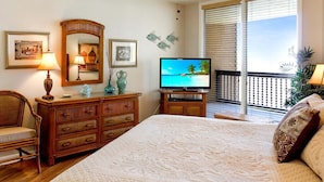 A bedroom with a bed, dresser, television, and a balcony with a view. - Sandpiper  #1007: Beachfront 2 Bedroom 2 Bathroom With Spectacular Views and 24 Hour Management (Port Aransas)