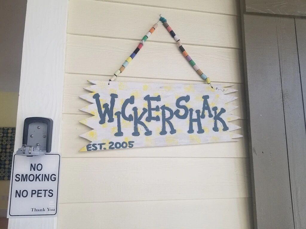A sign with the name 'WIGERSHAK' and 'EST. 2005' on a wooden wall, a 'NO SMOKING' sign, and a 'NO PETS' sign.