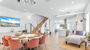 A modern living space with a dining area, a staircase, and a bedroom. -  Blissful Coral Villa EcoPool4b-4b (Miami)