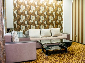 Luxe kamer | Woonkamer | Een 75-cm smart-tv met kabelzenders, een televisie en betaalfilms