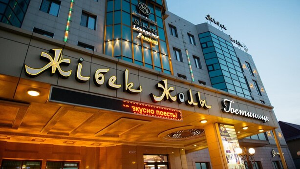 Ein Hotel mit einem auffälligen Schild, auf dem "Kiseki Hotel" und "Silkway Lounge Bar" steht.