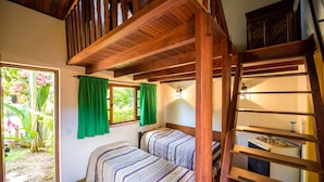 A bedroom with two beds, wooden beams, a ladder, and a window with green curtains. - Pouso Sambaquis (Ilhabela)