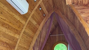 Un dormitorio acogedor en el ático con una cama litera, un sofá y una mesa de madera.