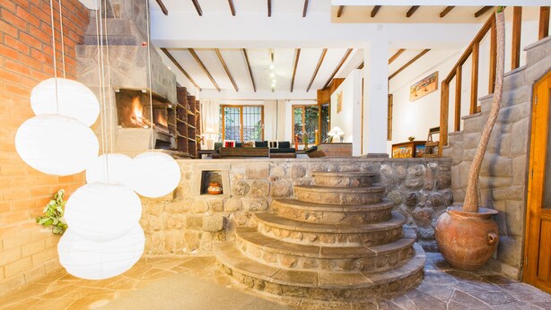 A stone staircase leading to a wooden door, a stone wall with a window, and a stone floor. - Unique House in Historical Center (Cuzco)