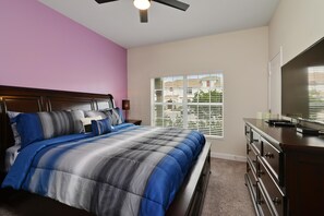 A bedroom with a bed, dresser, and a television. - Full Moon Lagoon by VillaDirect (Davenport)