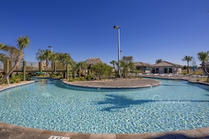 A clear swimming pool with a tiled edge, surrounded by palm trees and a fence. - Full Moon Lagoon by VillaDirect (Davenport)