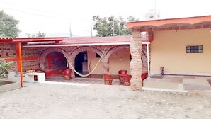 A building with a red roof, brick arches, and outdoor seating. - Beautiful country house (Jocotepec)