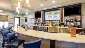 A bar area with a curved counter, multiple seating options, and a variety of bottles and glasses on display. - Home Away from Home by VillaDirect (Davenport)