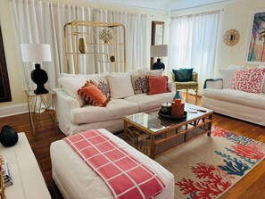 A living room with a white sofa, a coffee table, and a patterned rug.