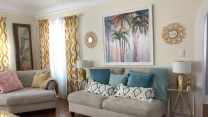 A living room with two sofas, a coffee table, and a painting on the wall.