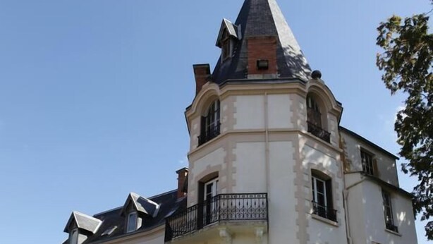 A multi-story building with a prominent tower, balconies, and a small tree in the courtyard. - Chateau les 4 saisons (Saint-Cirgues-sur-Couze)