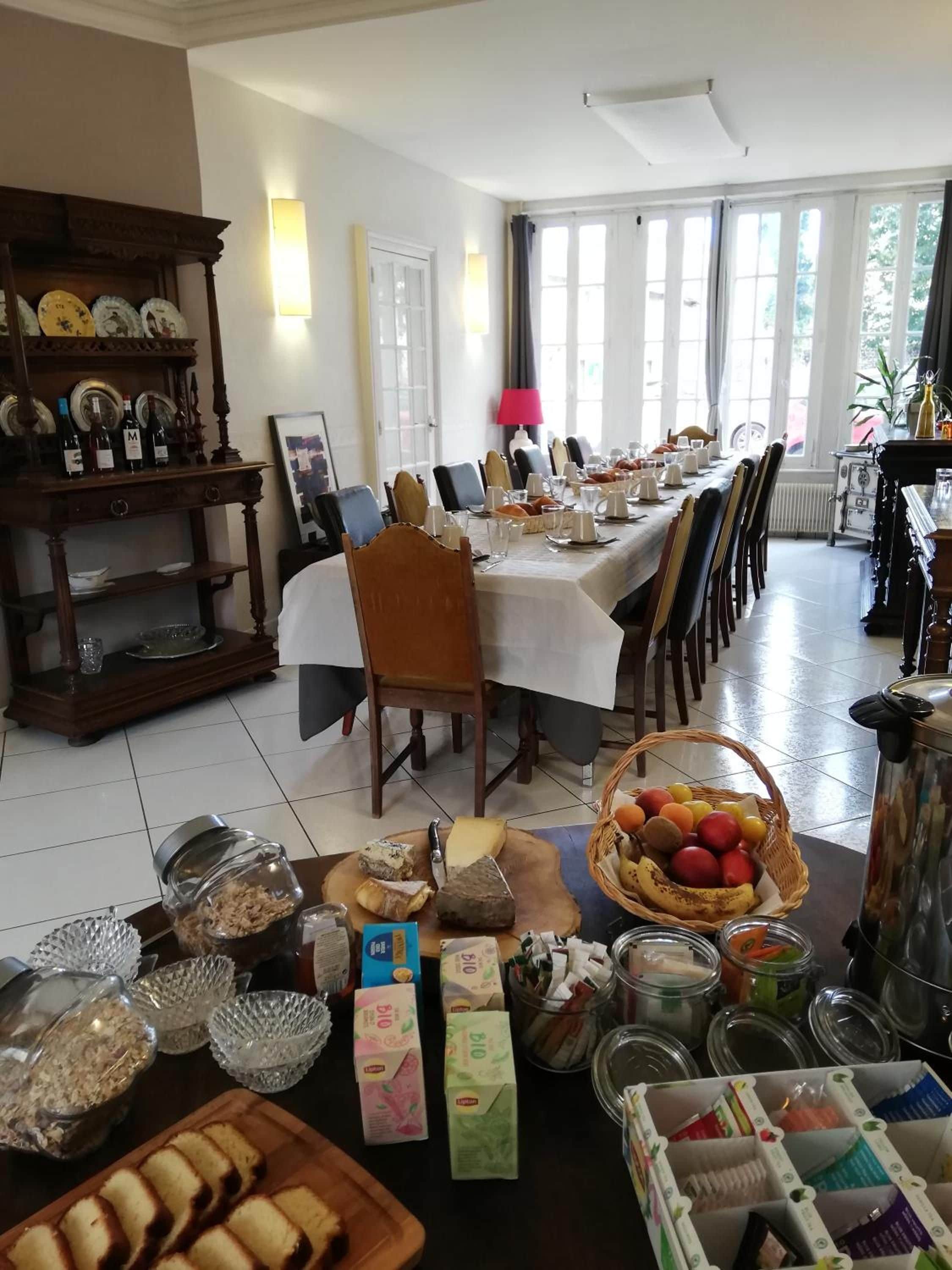 A dining area with a long table set for a meal, surrounded by chairs.